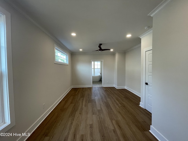 empty room featuring ornamental molding, dark wood finished floors, and baseboards