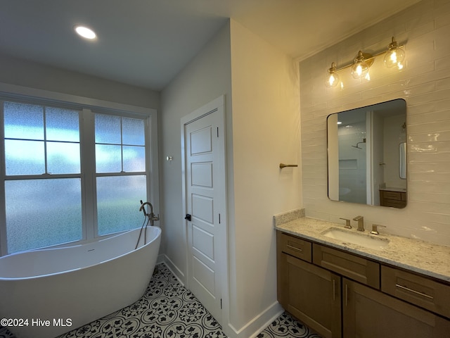 bathroom featuring a soaking tub, tile patterned flooring, vanity, and baseboards