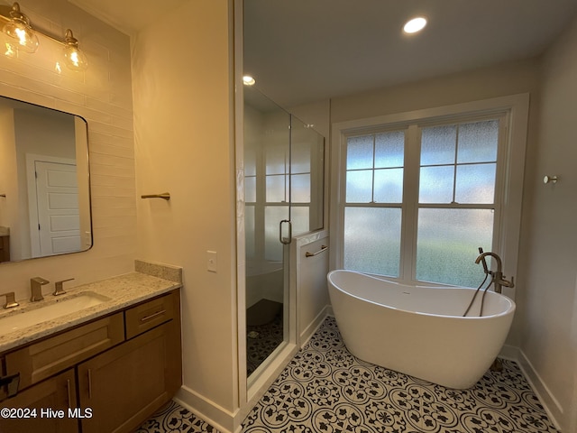 bathroom with vanity, baseboards, a freestanding bath, tile patterned floors, and a stall shower