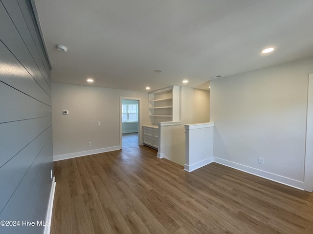 spare room with baseboards, dark wood-style flooring, visible vents, and recessed lighting