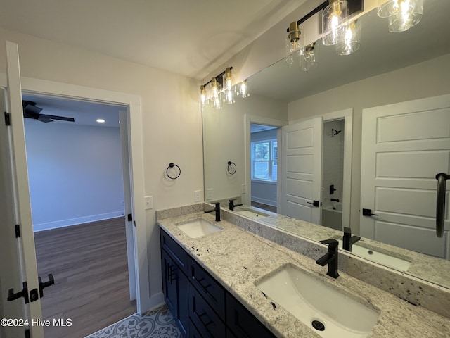 bathroom with double vanity, baseboards, and a sink