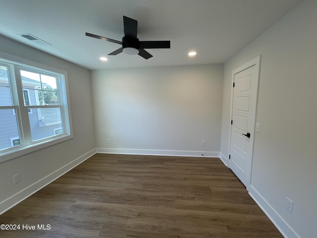 unfurnished room with recessed lighting, dark wood-style flooring, visible vents, and baseboards