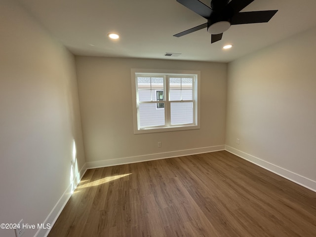 spare room with dark wood-style floors, recessed lighting, visible vents, and baseboards