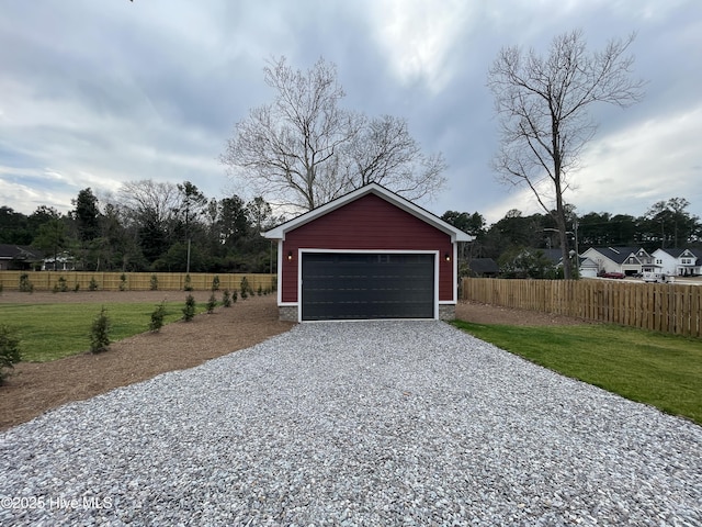 detached garage featuring fence