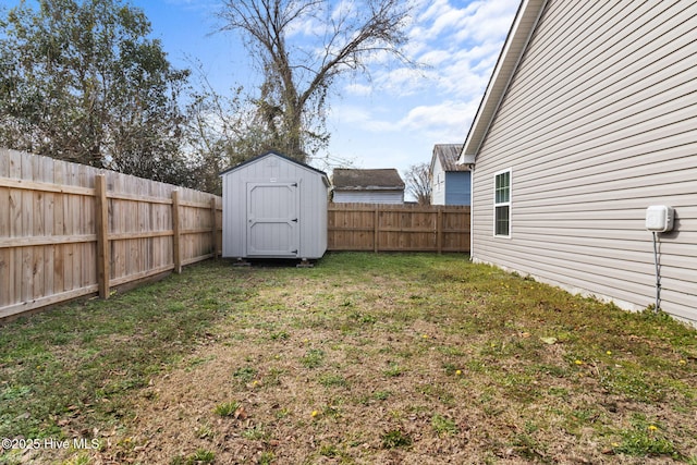 view of yard with a storage shed, an outbuilding, and a fenced backyard