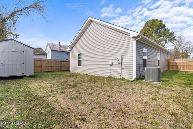 exterior space with a fenced backyard, a storage unit, and a lawn