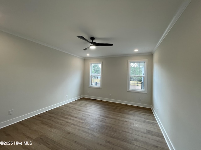 spare room featuring crown molding, recessed lighting, dark wood-type flooring, a ceiling fan, and baseboards