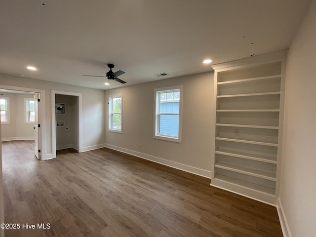 unfurnished room featuring visible vents, dark wood finished floors, and baseboards