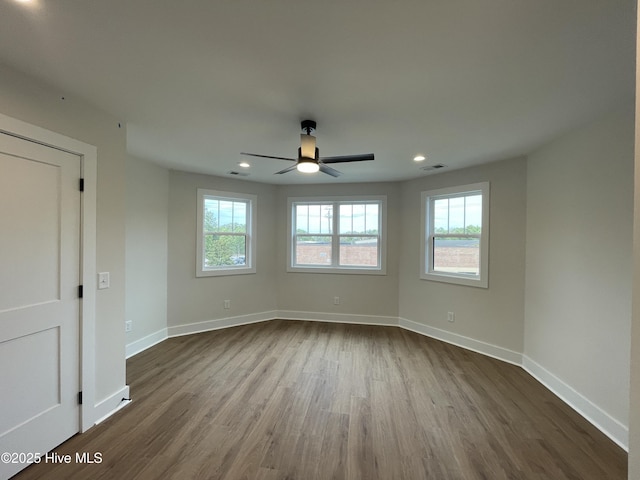 spare room featuring baseboards, visible vents, dark wood-style flooring, and recessed lighting