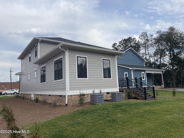 view of property exterior with central AC, a yard, and stairs