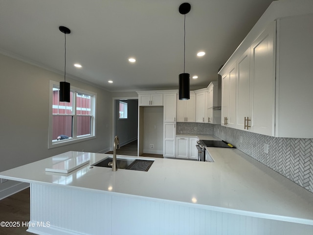 kitchen with white cabinets, decorative backsplash, a peninsula, stainless steel range with electric cooktop, and a sink