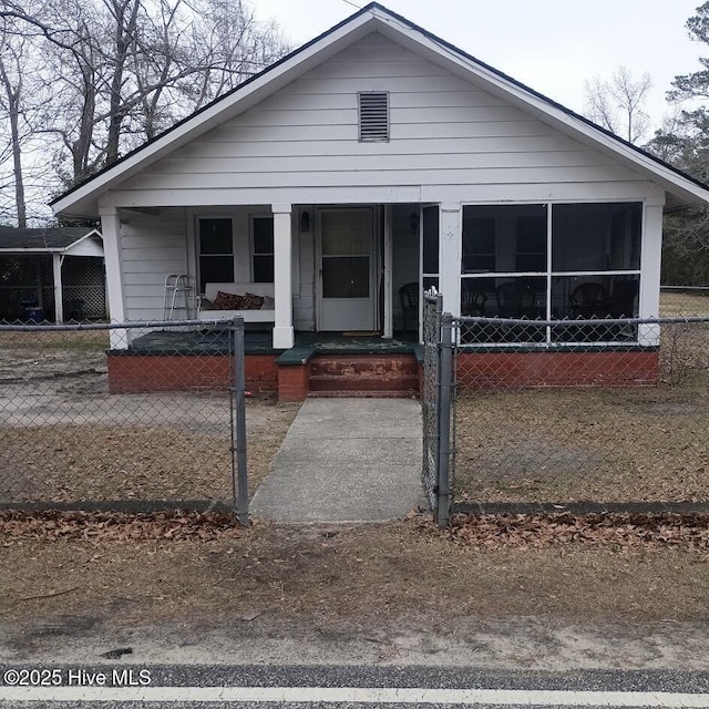 bungalow featuring covered porch, a fenced front yard, and a gate