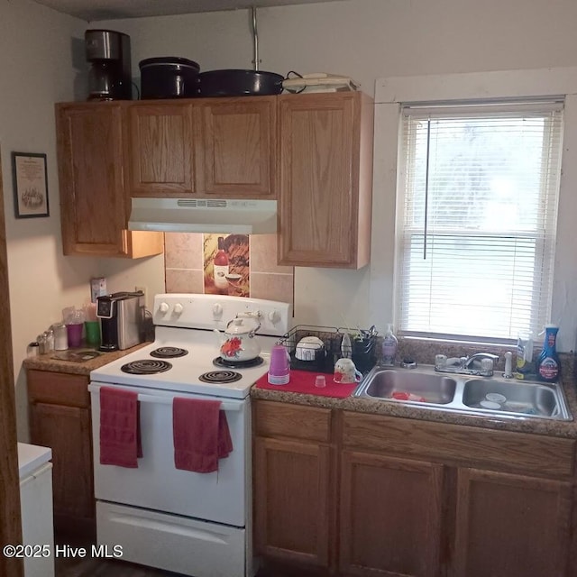 kitchen with under cabinet range hood, a sink, light countertops, backsplash, and white electric range oven