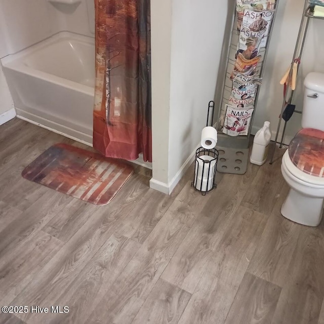 full bath with toilet, baseboards, and wood finished floors