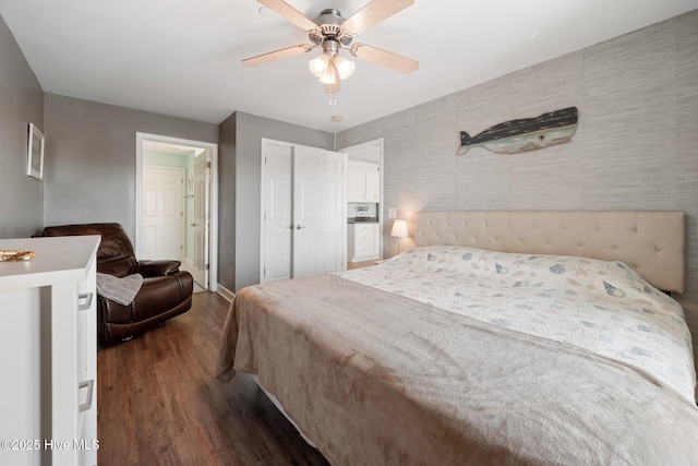 bedroom featuring a ceiling fan, a closet, baseboards, and dark wood-type flooring