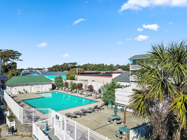 community pool featuring a patio and fence