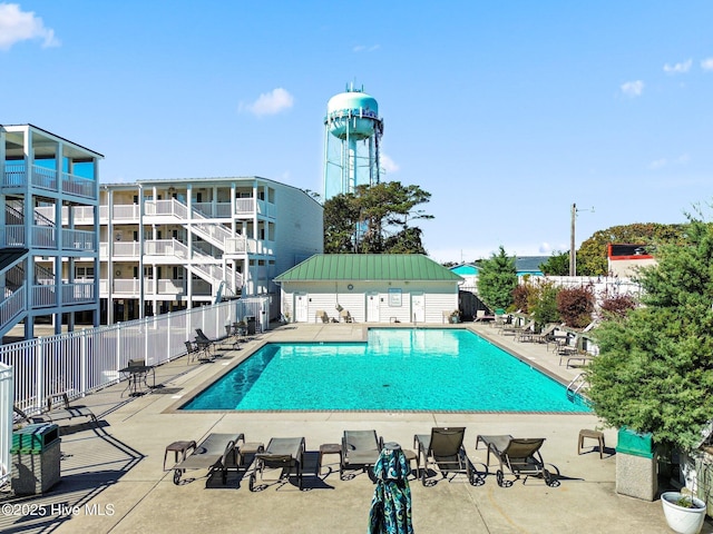 community pool with fence and a patio