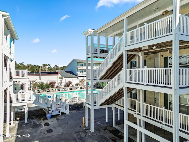 exterior space featuring a community pool and stairs