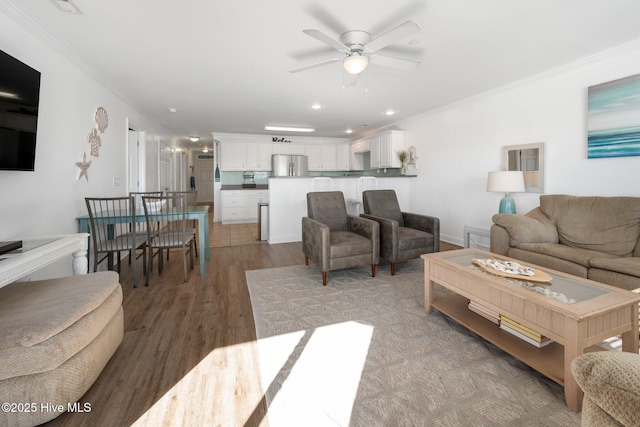 living area with ceiling fan, light wood-style floors, recessed lighting, and crown molding