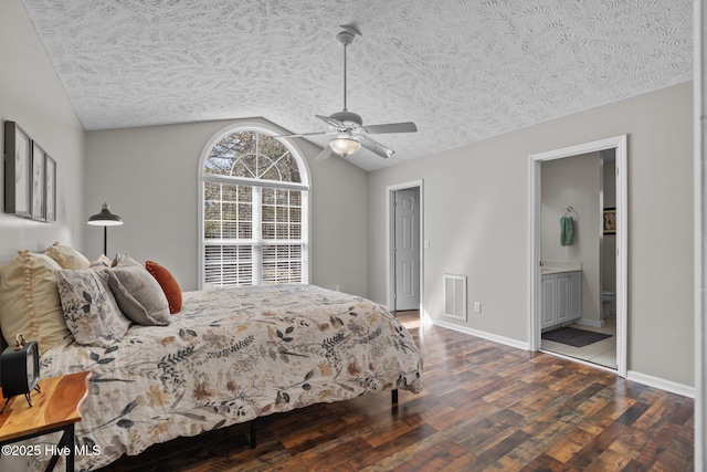 bedroom featuring wood finished floors, baseboards, visible vents, vaulted ceiling, and a textured ceiling