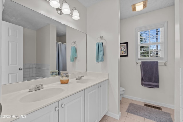 bathroom featuring tile patterned floors, visible vents, toilet, and a sink