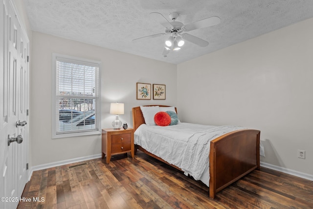 bedroom with ceiling fan, a textured ceiling, baseboards, and hardwood / wood-style floors