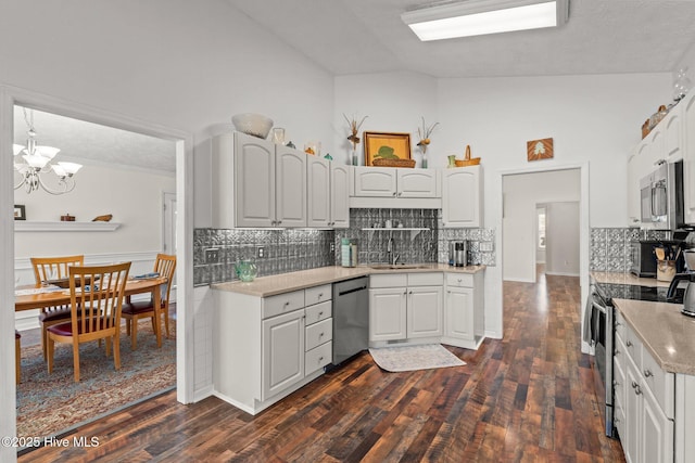 kitchen with a sink, light countertops, white cabinets, appliances with stainless steel finishes, and a chandelier