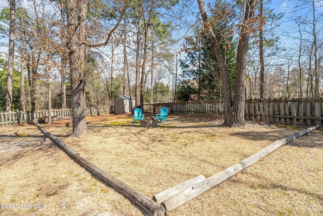 view of yard with an outbuilding, a fenced backyard, and a shed