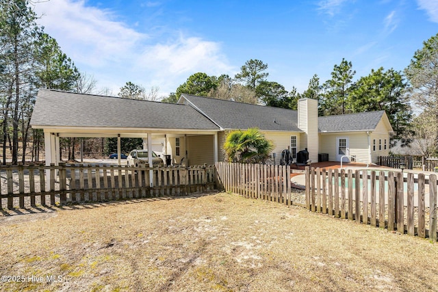 view of front of house featuring a shingled roof, a chimney, and fence