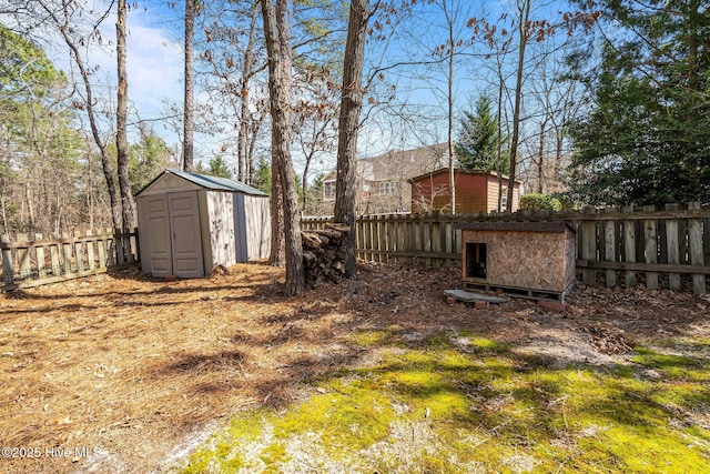 view of yard with a storage shed, a fenced backyard, and an outdoor structure