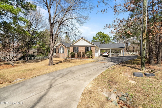 ranch-style house with driveway, an attached carport, brick siding, and fence