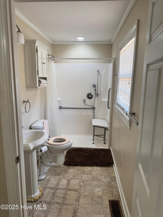 bathroom featuring crown molding, visible vents, toilet, a stall shower, and baseboards