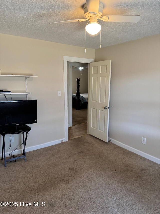 empty room featuring a ceiling fan, carpet flooring, a textured ceiling, and baseboards