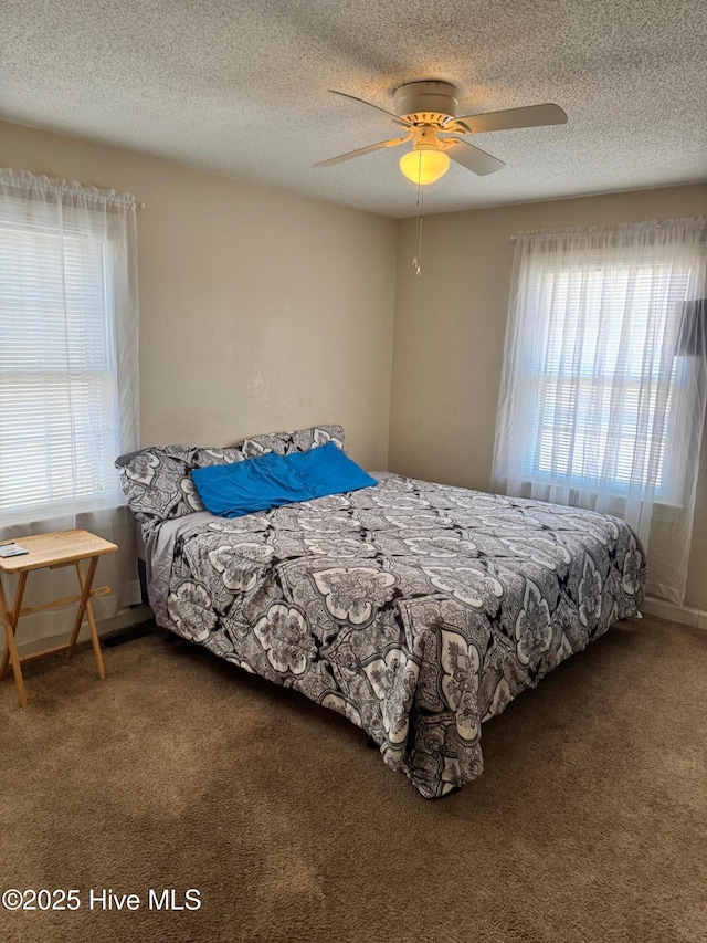 bedroom with a textured ceiling, ceiling fan, and carpet flooring