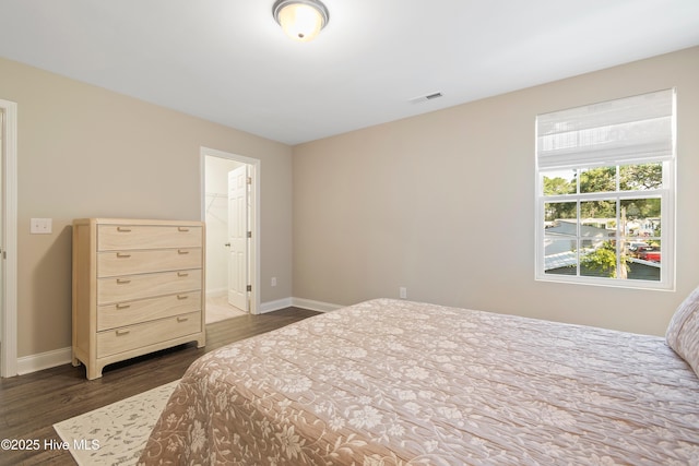 bedroom with dark wood-style flooring, visible vents, and baseboards