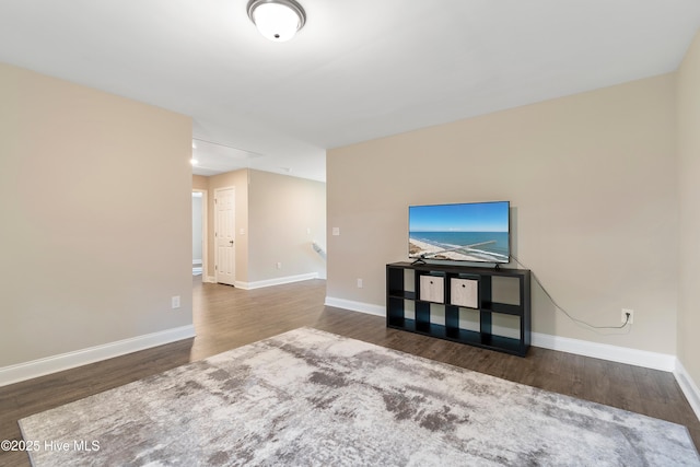 unfurnished living room with baseboards and wood finished floors