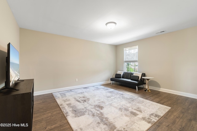 living area with baseboards, visible vents, and dark wood-style flooring