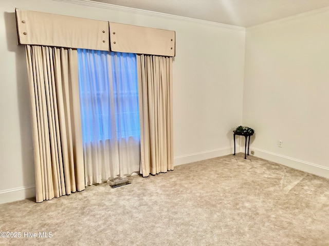 carpeted empty room with baseboards and crown molding