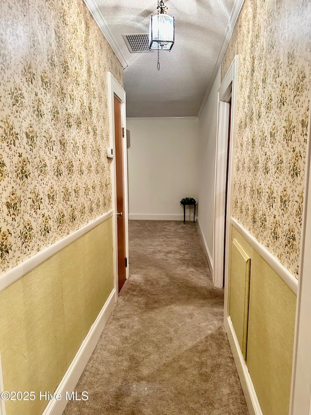 corridor featuring ornamental molding, wainscoting, carpet flooring, and wallpapered walls