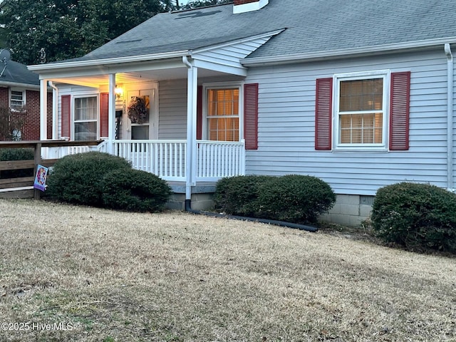 view of front of home featuring crawl space, a shingled roof, a chimney, and a porch