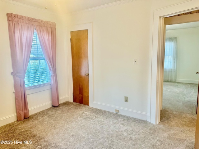 unfurnished bedroom with baseboards, ornamental molding, and carpet flooring