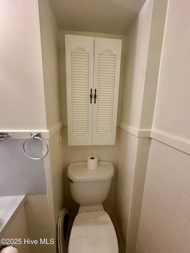 bathroom with wainscoting and toilet