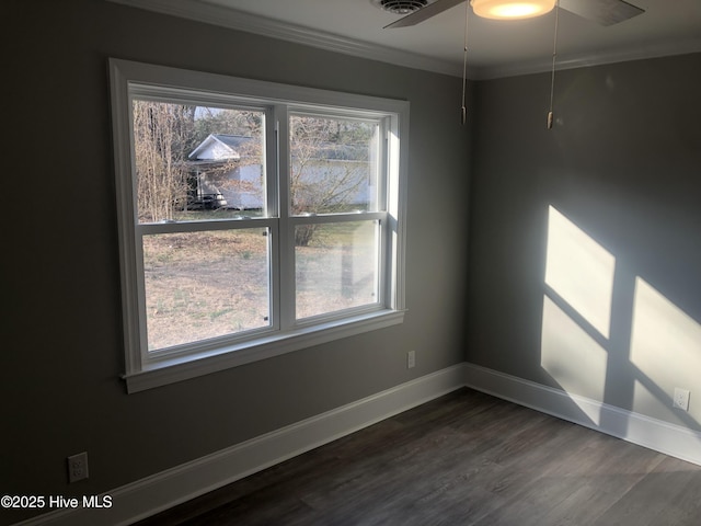 unfurnished room featuring crown molding, dark wood finished floors, baseboards, and a ceiling fan