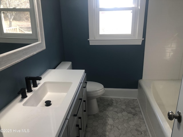 bathroom with a wealth of natural light, tile patterned flooring, vanity, and toilet