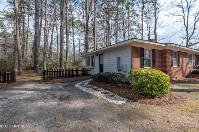 view of side of home with fence and brick siding