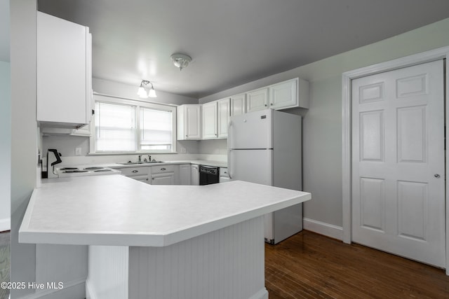 kitchen with black dishwasher, range, freestanding refrigerator, a peninsula, and light countertops