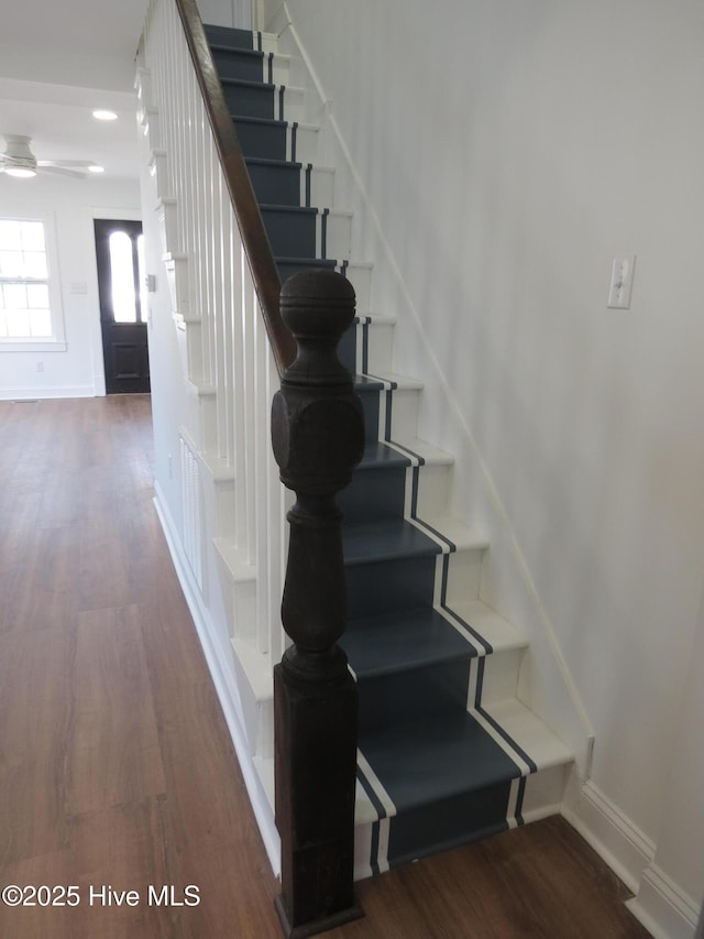 staircase with ceiling fan, wood finished floors, and baseboards