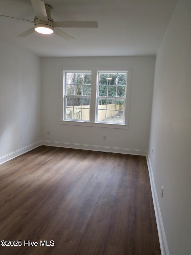 unfurnished room featuring dark wood-style floors, baseboards, and a ceiling fan