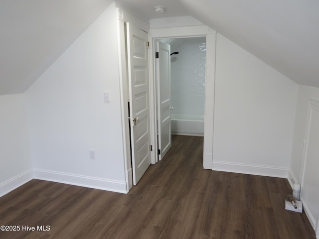 additional living space with lofted ceiling, dark wood finished floors, and baseboards