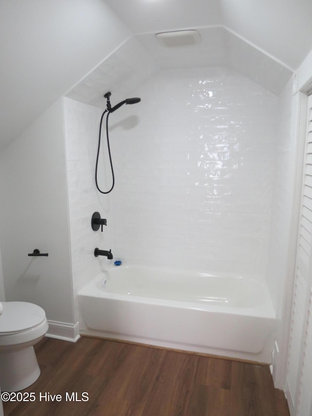 full bathroom featuring lofted ceiling, shower / bath combination, toilet, and wood finished floors